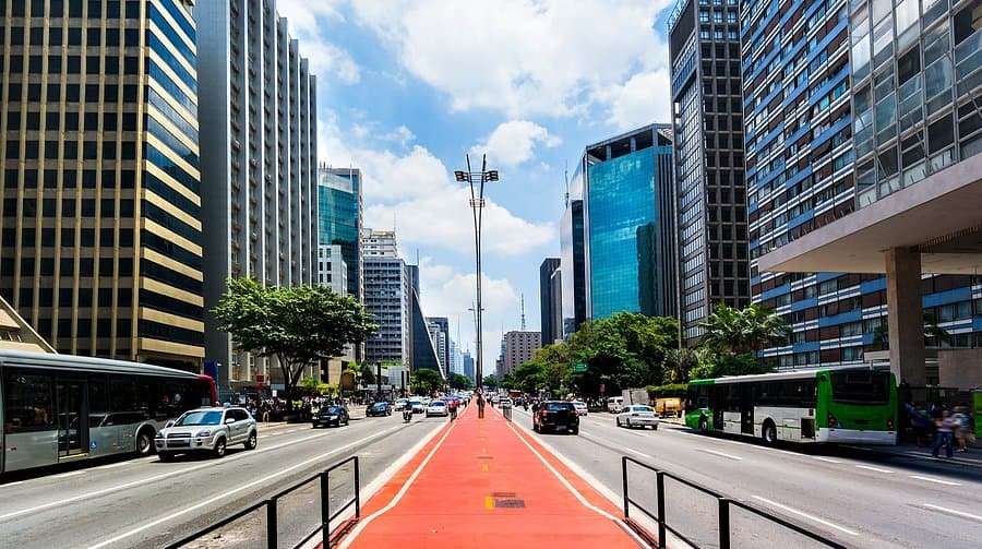 Avenida Paulista com ciclovia, ônibus e edifícios ao redor